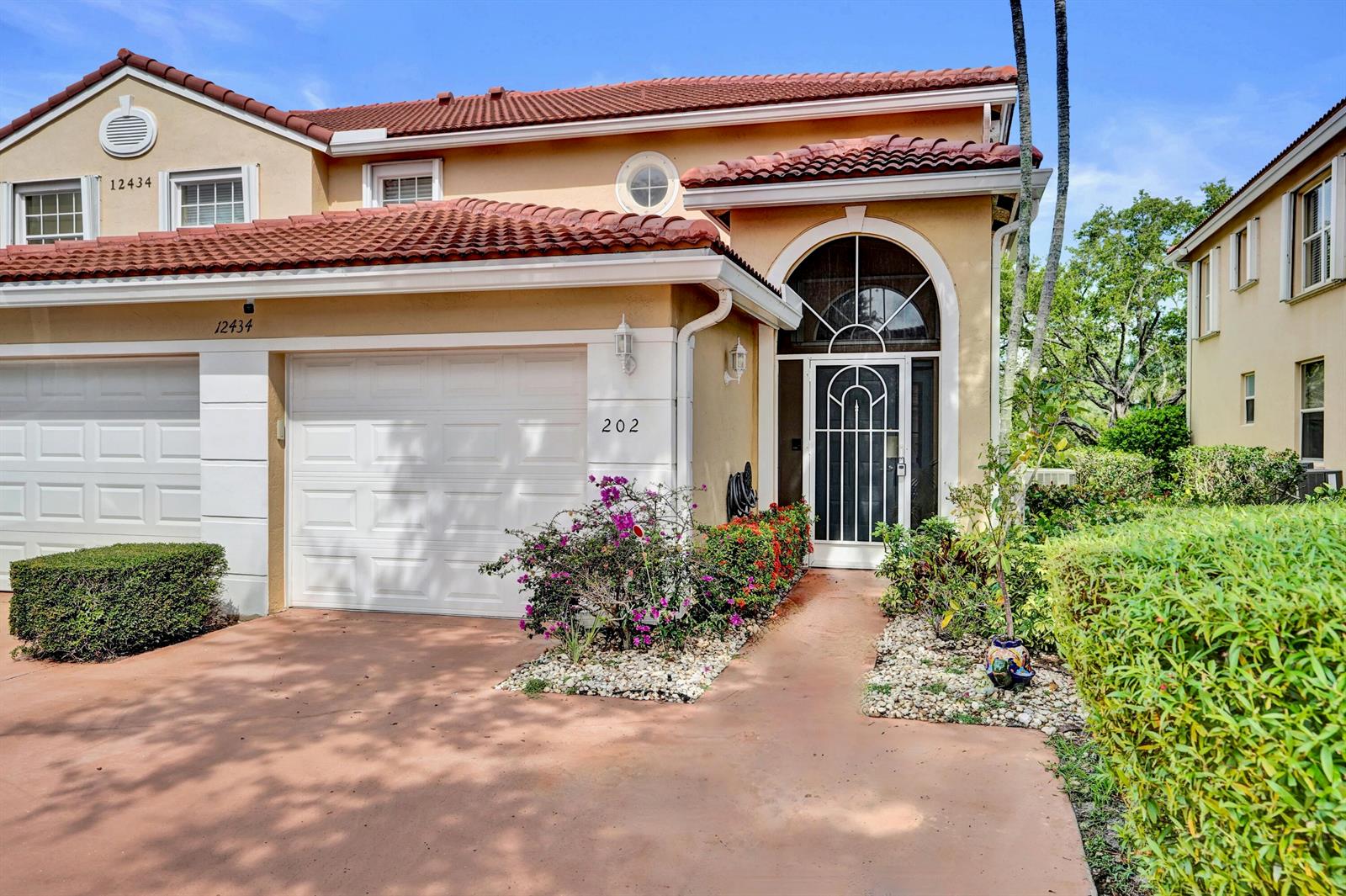 The exterior of a two-story stucco house features a tile roof and a garage — 12434 Crystal Pointe Drive # 202, Boynton Beach FL 33437, BOYNTON BEACH, FL