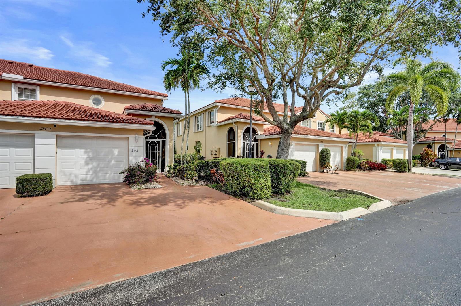 A row of two-story stucco townhouses with red tile roofs and attached garages — 12434 Crystal Pointe Drive # 202, Boynton Beach FL 33437, BOYNTON BEACH, FL