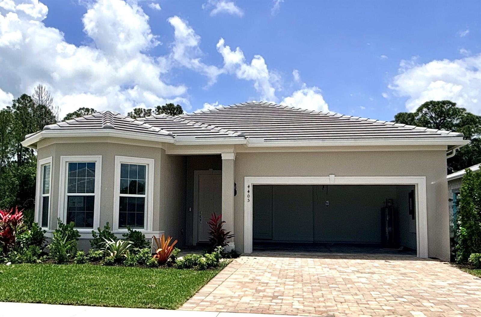 A single-story house with a beige stucco exterior, a tiled roof, and a paved driveway — 4405 SW Cornerstone Way # 167, Stuart FL 34997, STUART, FL