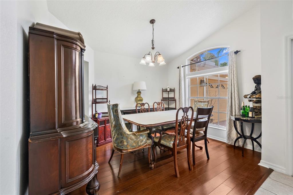 A spacious covered patio features stone flooring, wicker furniture, a ceiling fan, and a grill — 2651 RAMBLING OAKS WAY, KISSIMMEE, FL
