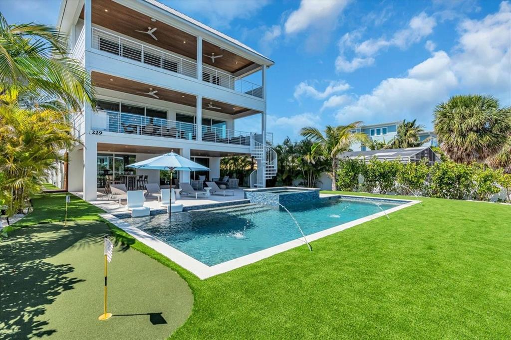 A three-story house with balconies, a swimming pool, and a putting green in the backyard — 229 WILLOW AVENUE, ANNA MARIA, FL