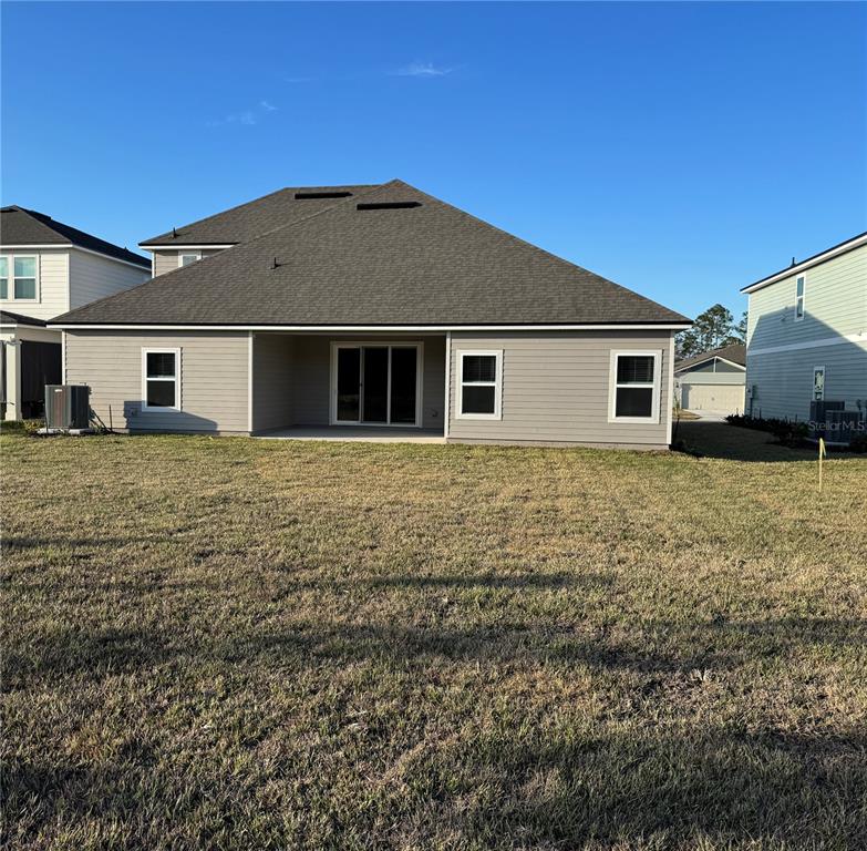 An entryway with light wood-look flooring, white walls, a glass-paneled front door, and two doorways — 3315 HARVESTERS COURT, GREEN COVE SPRINGS, FL