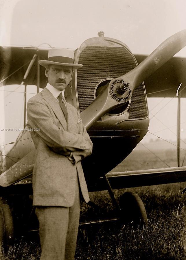 A man in a suit and hat stands with arms crossed before a vintage airplane — 200 Azure Way, Miami Springs FL 33166, MIAMI SPRINGS, FL