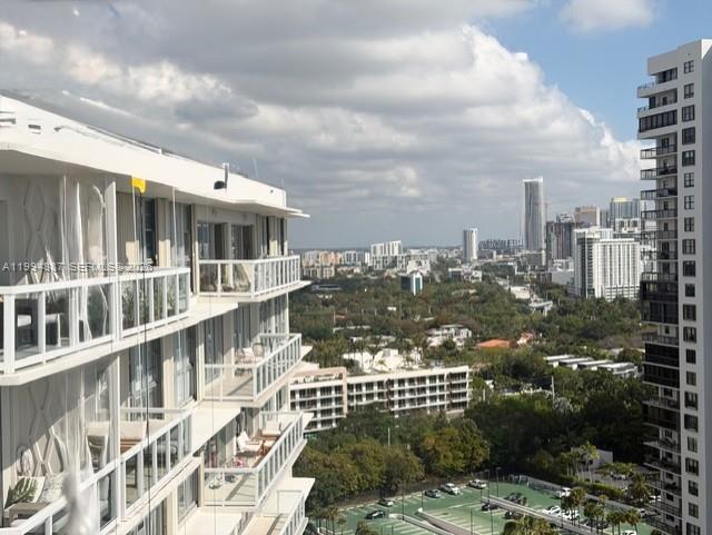 An exterior view of a high-rise apartment building overlooking a city skyline and parking lot — 2451 Brickell Ave, Miami FL 33129, MIAMI, FL