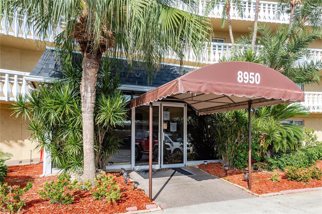The exterior entrance of a building features a brown awning with the number 8950 — 8950 PARK BOULEVARD UNIT 702, SEMINOLE, FL