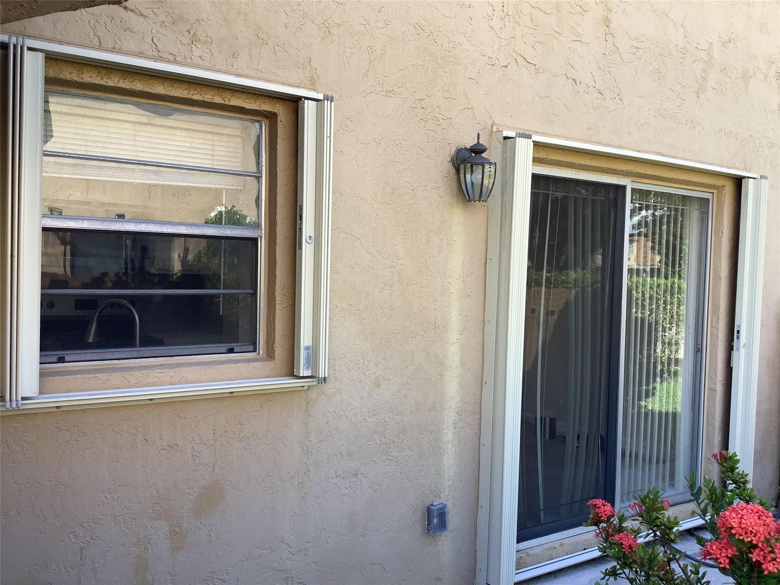 An exterior view of a stucco wall featuring a window and a sliding glass door — 3581 NW 95th Terrace # 601, Sunrise FL 33351, SUNRISE, FL