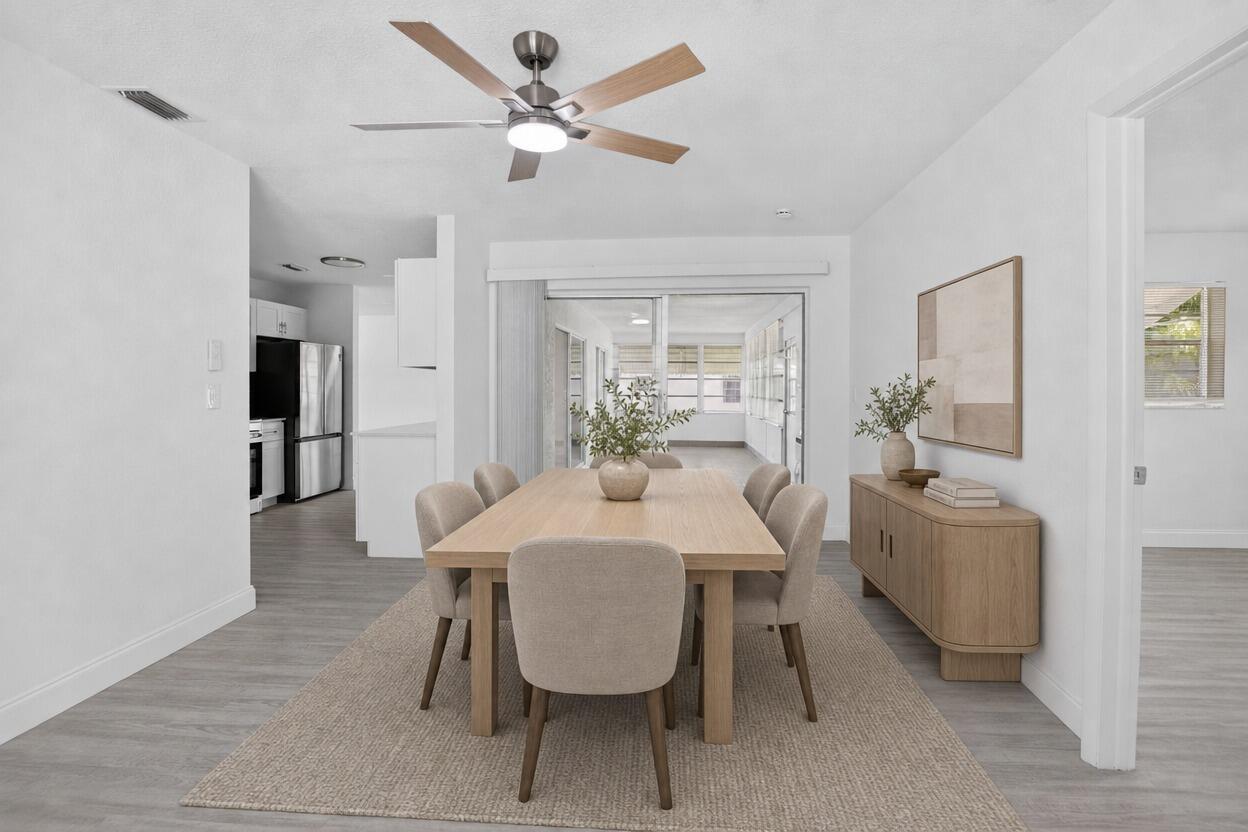 A dining room features a wooden table, six upholstered chairs, a sideboard, and a ceiling fan — 703 SW 18th Street, Boynton Beach FL 33426, BOYNTON BEACH, FL