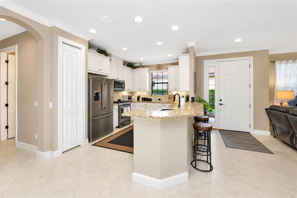 A kitchen with white cabinets, granite countertops, stainless steel appliances, and a breakfast bar — 5126 SAVONA RUN, BRADENTON, FL