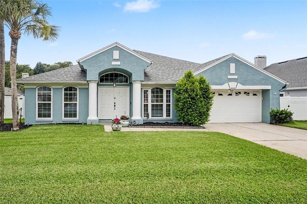 A blue single-story house with a white double door, columns, and a two-car garage — 5638 CATSKILL COURT, WINTER SPRINGS, FL