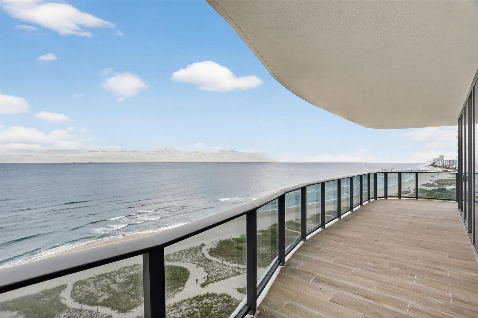 A curved balcony with glass railings overlooks the ocean and a sandy beach — 900 N Ocean Boulevard # 1401, Pompano Beach FL 33062, POMPANO BEACH, FL