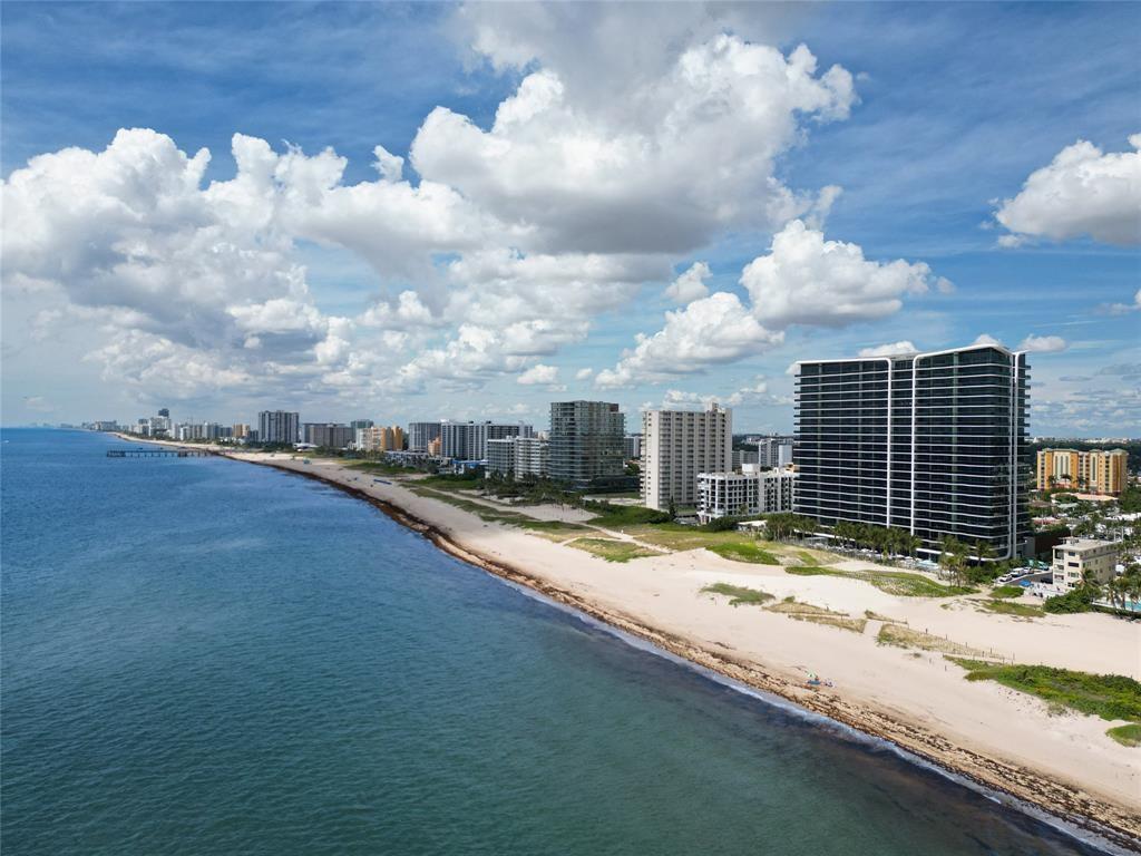 An aerial view of a sandy beach lined with high-rise residential buildings along the ocean — 900 N Ocean Boulevard # 1401, Pompano Beach FL 33062, POMPANO BEACH, FL