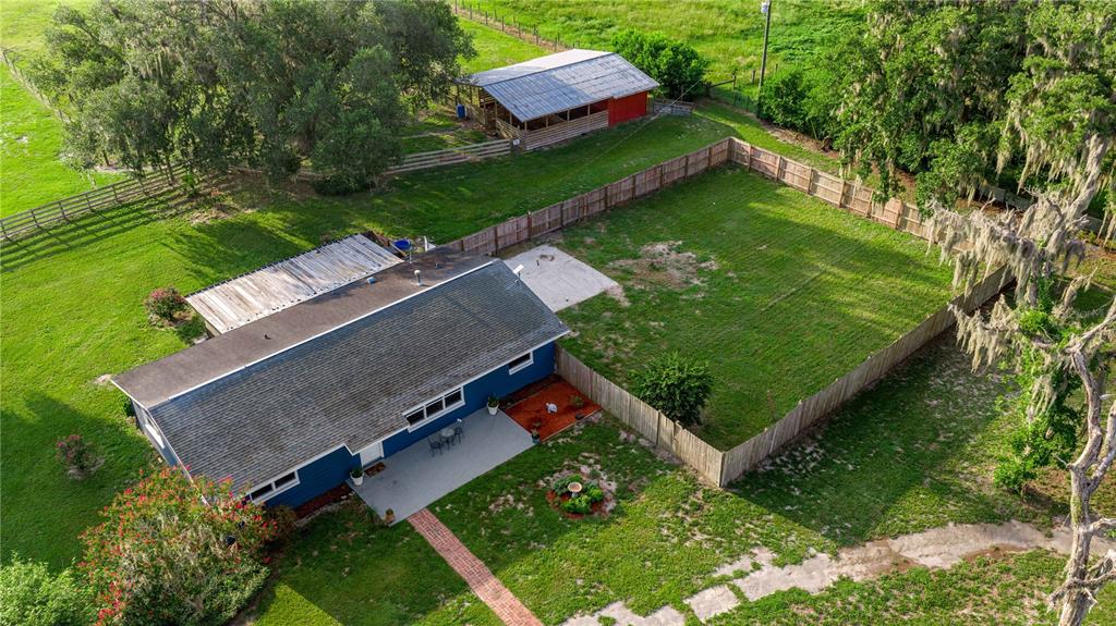 An aerial view shows a blue house with a fenced yard and a detached barn — 15027 SW 91ST STREET, ARCHER, FL