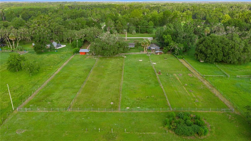 An aerial view shows a fenced grassy lot with a small red shed and house — 15027 SW 91ST STREET, ARCHER, FL
