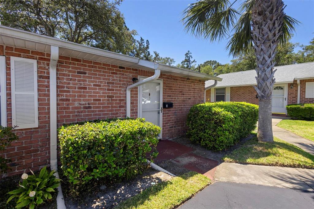 A brick exterior of a single-story residential building with a front door and landscaping — 3 FAIRWAY COURT, DELAND, FL