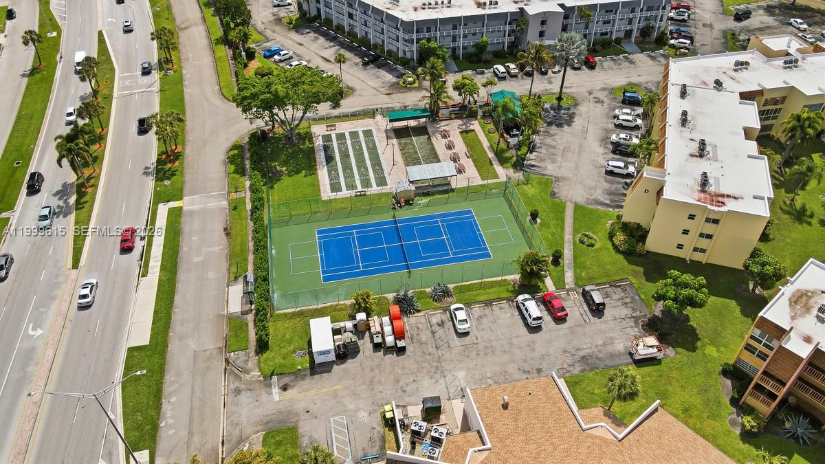 An aerial view shows a blue tennis court, shuffleboard courts, and surrounding apartment buildings — 6870 Royal Palm Blvd # 209M, Margate FL 33063, MARGATE, FL