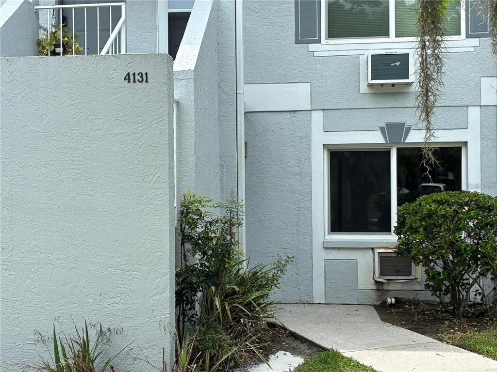 The exterior of a light blue multi-story building features a walkway and a small balcony — 4131 DOLPHIN DRIVE UNIT 4131, TAMPA, FL
