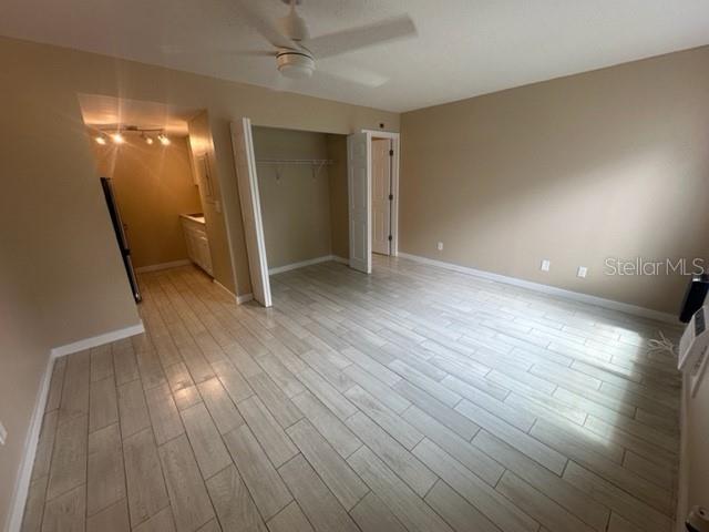 An empty room features light-colored wood-look tile flooring, a ceiling fan, and a closet — 4131 DOLPHIN DRIVE UNIT 4131, TAMPA, FL