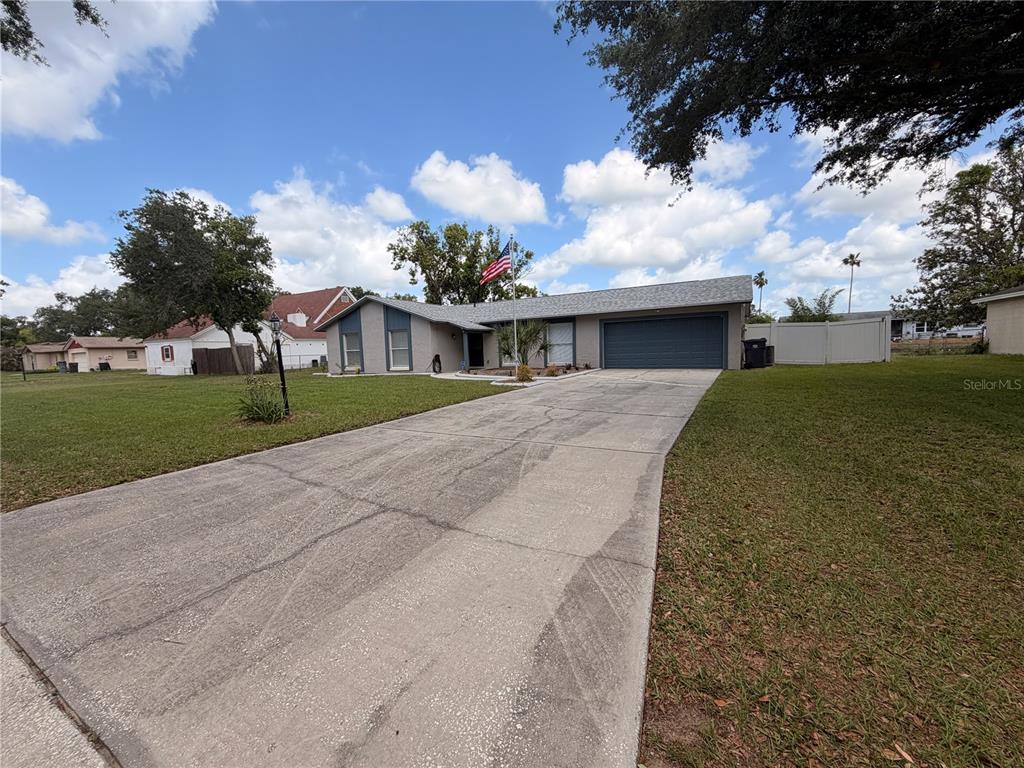 A single-story house with a gray exterior, two-car garage, and a concrete driveway — 1210 LADY ELAINE DRIVE, VALRICO, FL