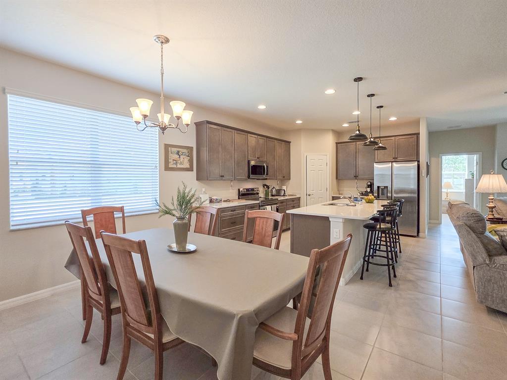 A dining area with a table and chairs sits adjacent to an open-concept kitchen — 8 LAKELAND WAY, PALM COAST, FL