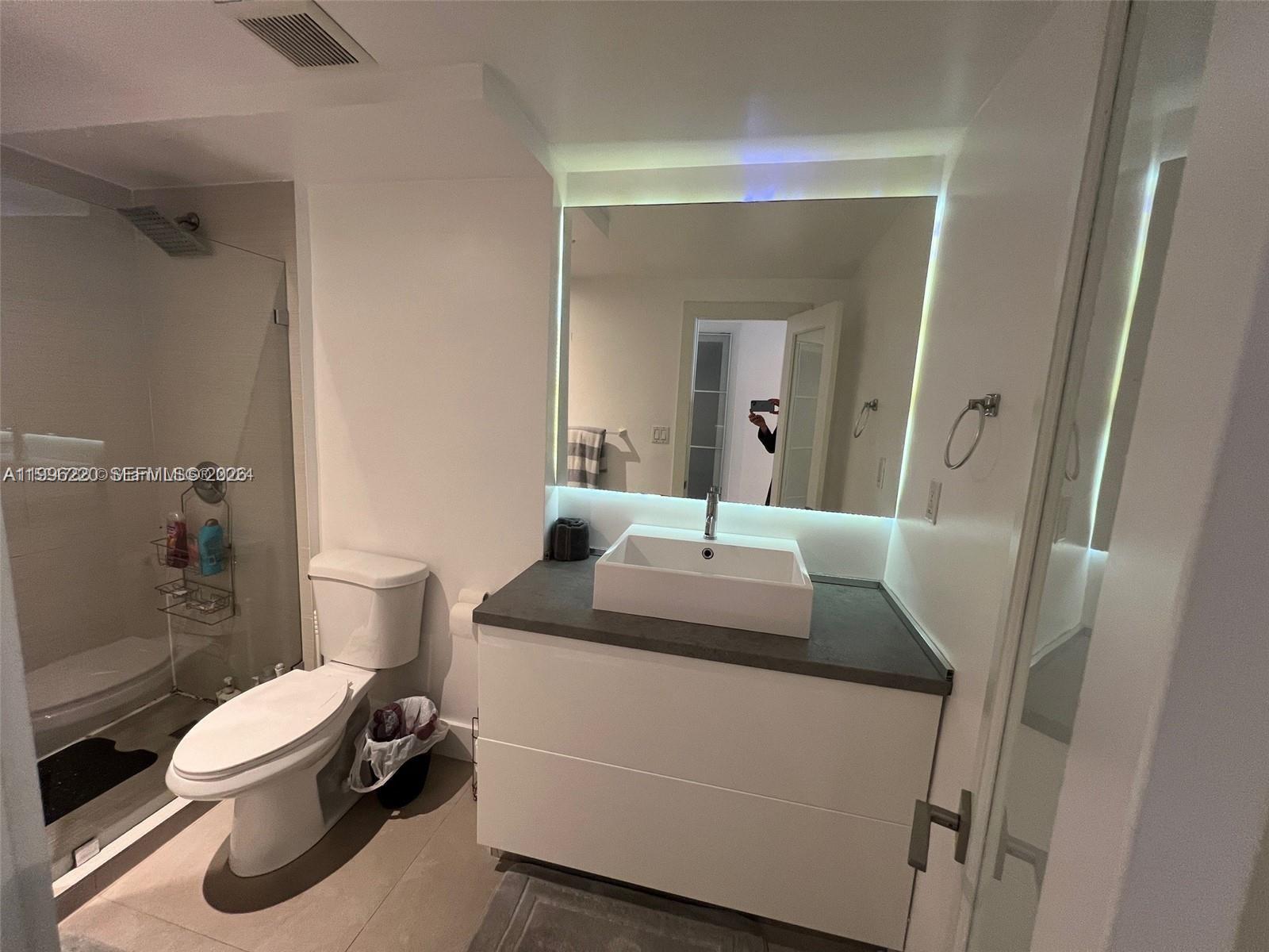 A modern bathroom features a vessel sink vanity, a backlit mirror, and a glass shower — 100 Lincoln Rd # 620, Miami Beach FL 33139, MIAMI BEACH, FL