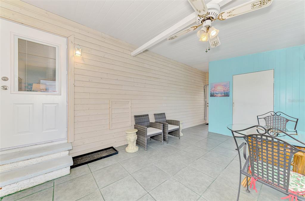 A covered patio features light-colored wood walls, a blue accent wall, and tile flooring — 6639 VISTA LANE, NORTH PORT, FL
