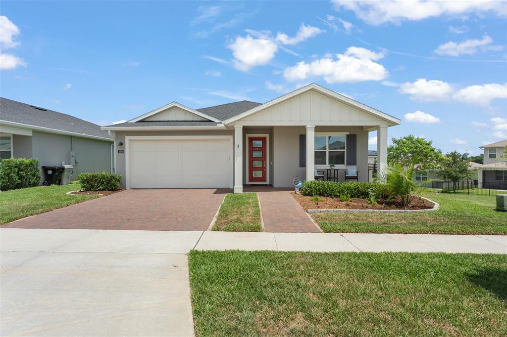 A single-story suburban house features a red front door, a brick driveway, and a porch — 2790 PARK RIDGE STREET, APOPKA, FL