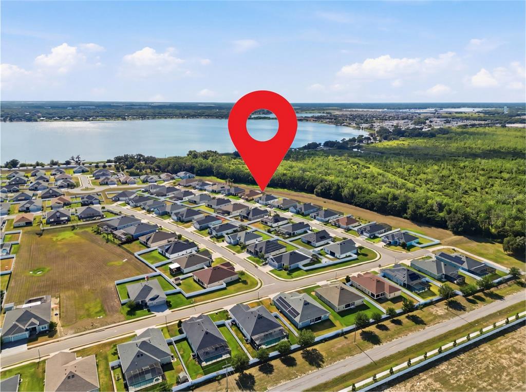 An aerial view shows a residential neighborhood with a red location pin above a house — 319 TRAVELERS CREEK DRIVE, AUBURNDALE, FL