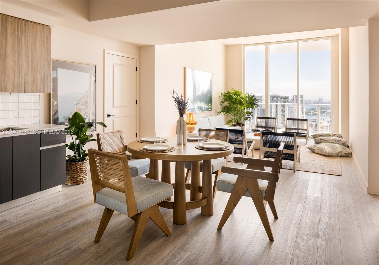 A dining area with a round wooden table and chairs sits beside a bright living space — 275 SW 6th St # 2006, Miami FL 33130, MIAMI, FL