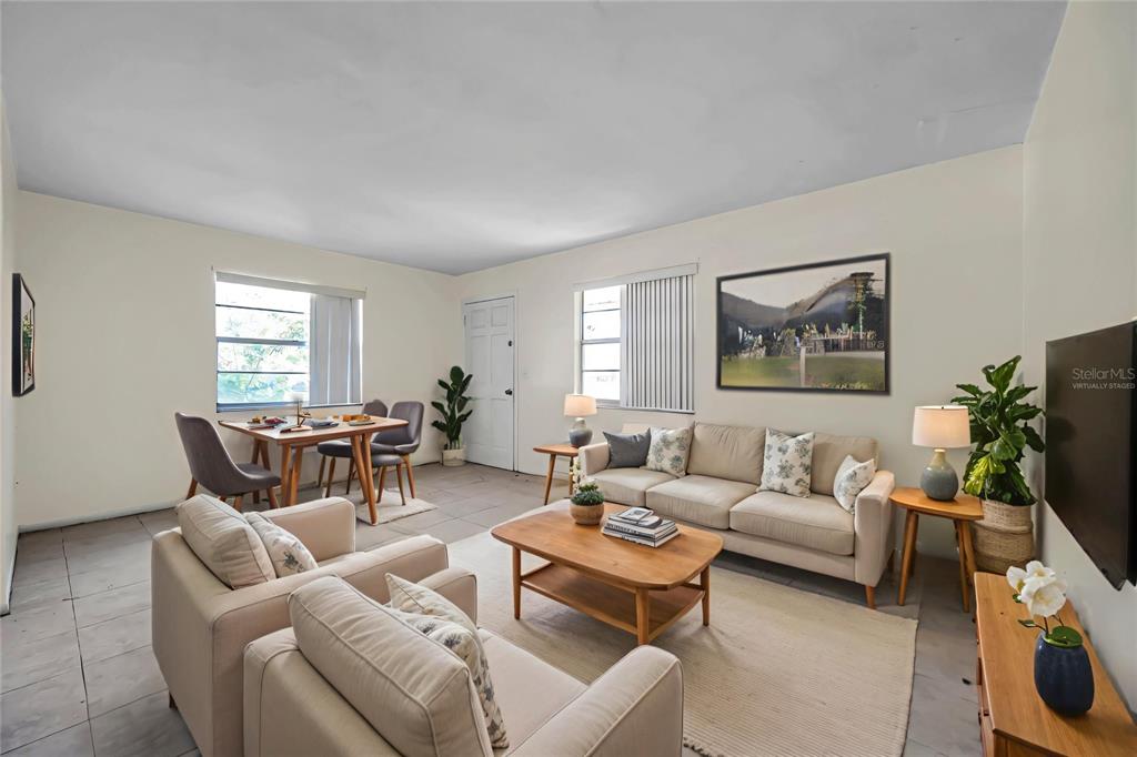 This living and dining area features tile flooring, neutral walls, and virtual staging furniture — 926 LAKE PALMS DRIVE, LARGO, FL