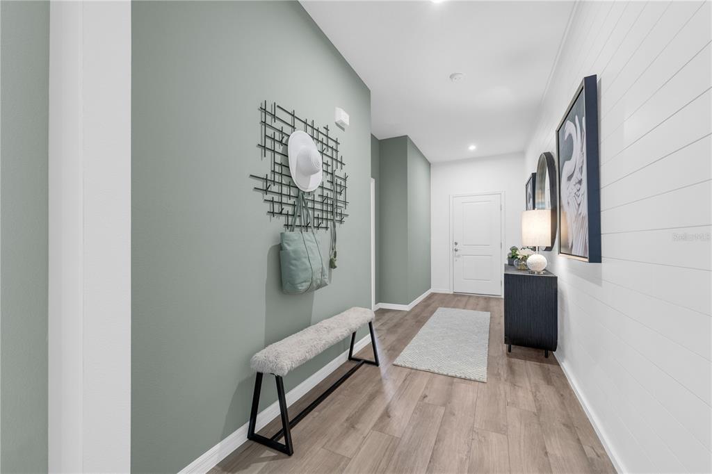 A hallway features a sage green accent wall, a bench, and white shiplap paneling — 23595 GRINDSTONE WAY, SORRENTO, FL