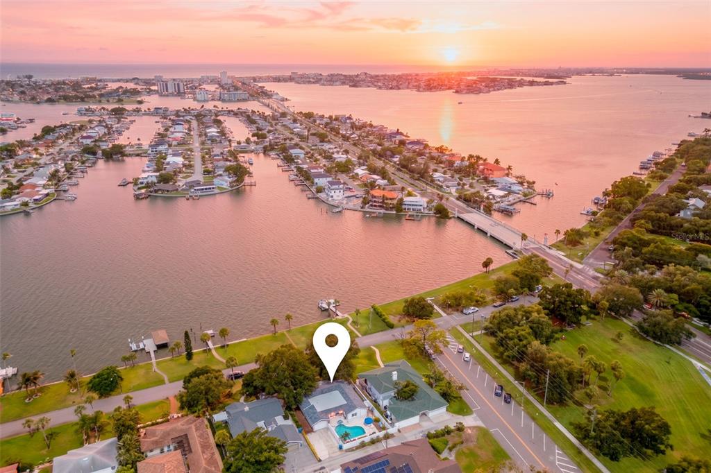 An aerial view shows a waterfront house with a pool and a nearby bridge — 110 SUNSET DRIVE S, ST PETERSBURG, FL