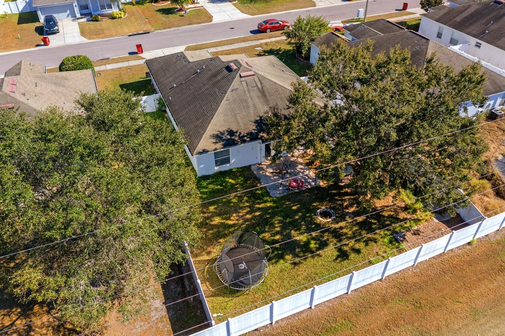 An aerial view shows a house with a fenced backyard, a trampoline, and large trees — 3609 TRAPNELL GROVE LOOP, PLANT CITY, FL