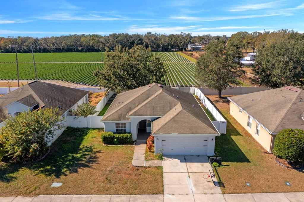 An aerial view shows a suburban house with a tan roof and a white garage — 3609 TRAPNELL GROVE LOOP, PLANT CITY, FL