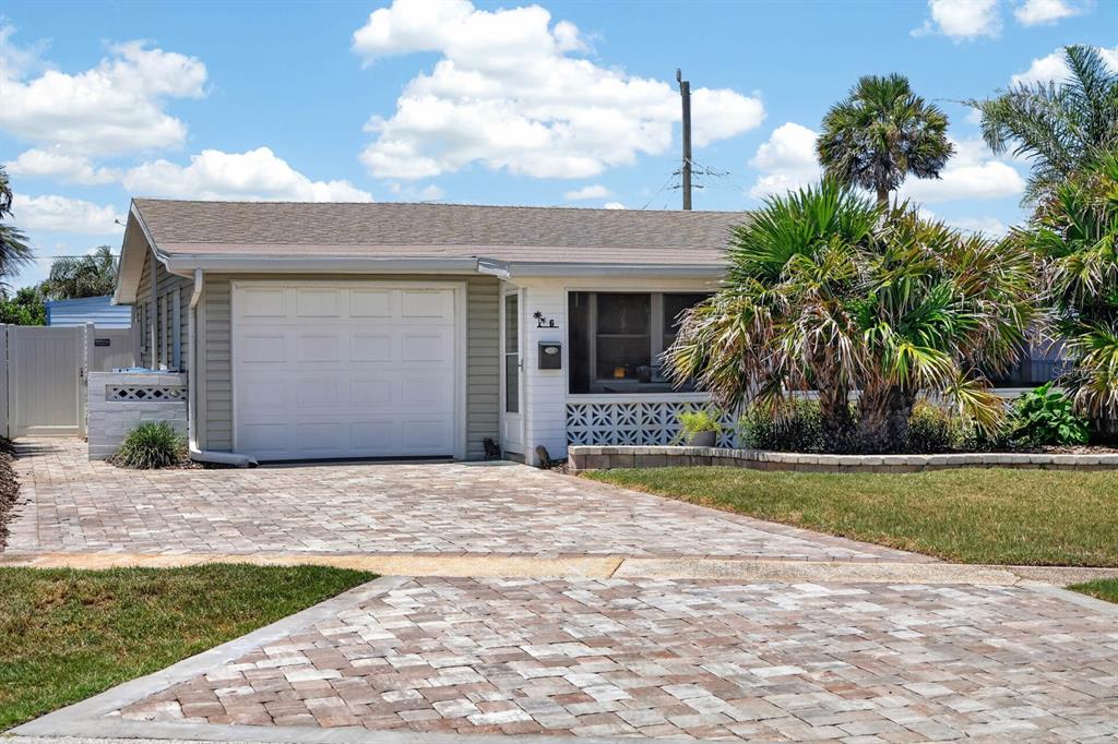 A single-story house with a white garage door, a paved driveway, and a decorative block wall — 6 TROPICAL DRIVE, ORMOND BEACH, FL
