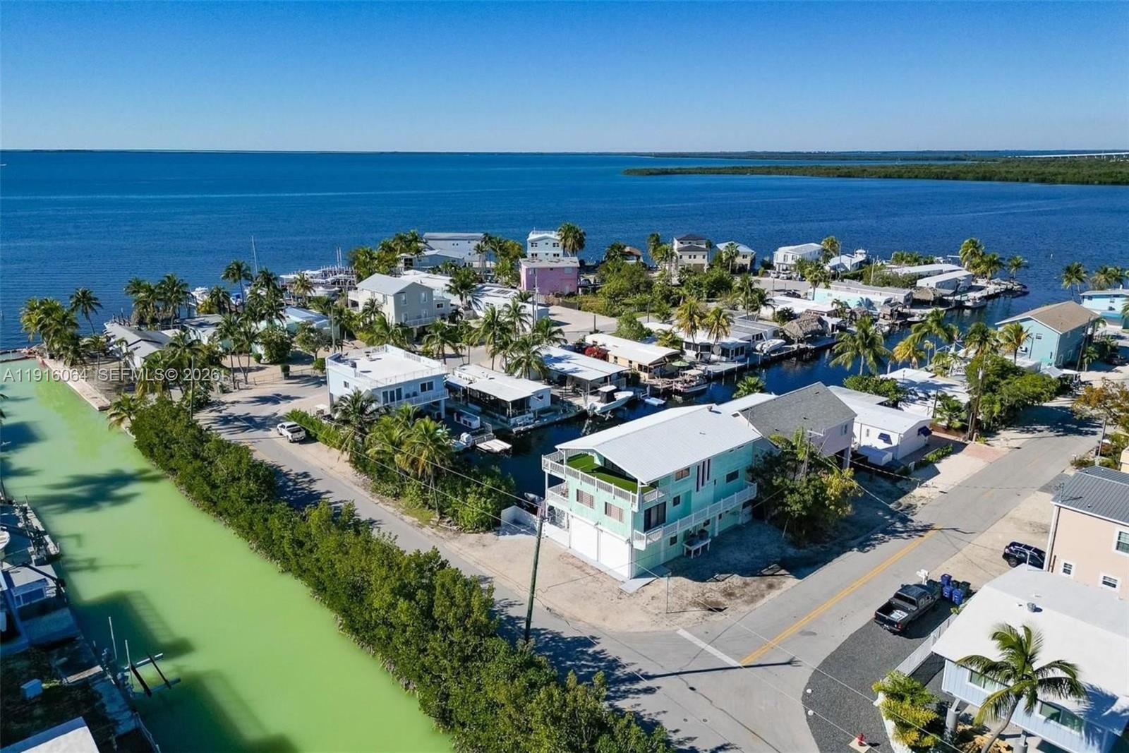 An aerial view shows waterfront houses along a canal leading to the open ocean — 2 Snipe Rd, Key Largo FL 33037, KEY LARGO, FL