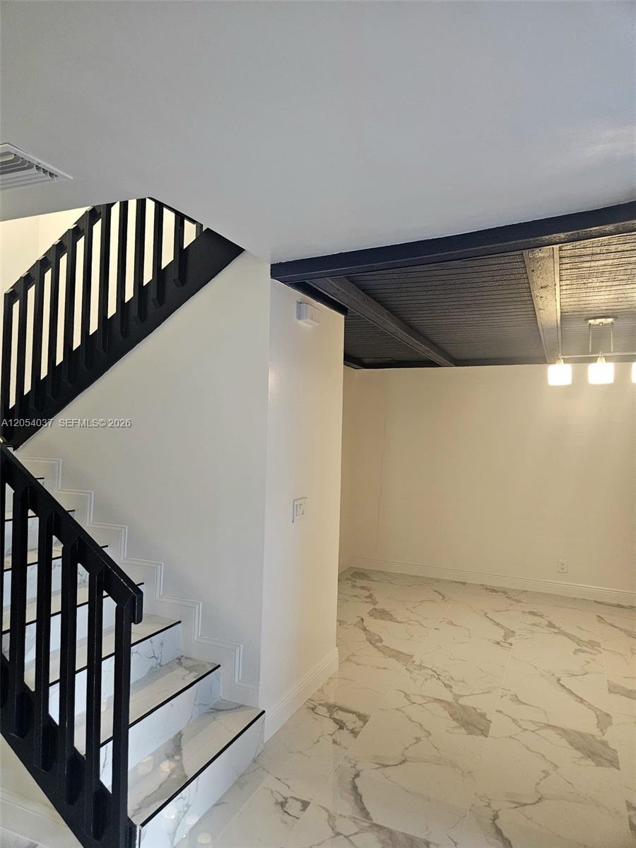 A staircase with black railings and marble-look steps sits beside a room with tiled floors — 2950 Kirk Rd # 2950, Lake Worth FL 33461, LAKE WORTH, FL