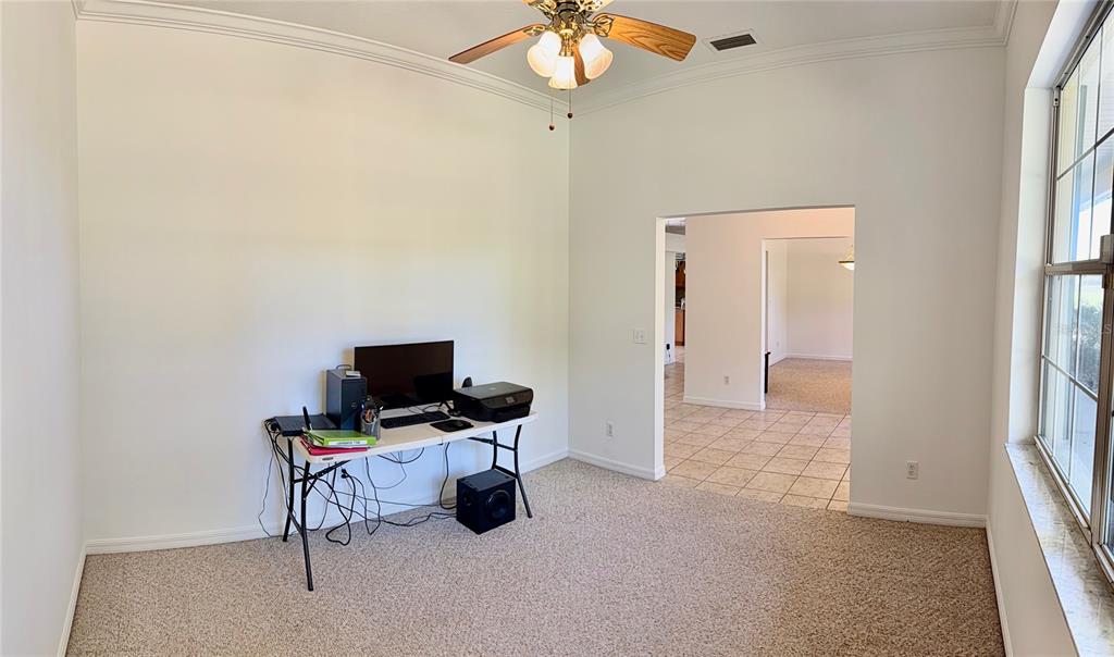 A home office features a wooden desk, a bookshelf, a leather chair, and a world map — 3701 W ANTHONY ROAD, OCALA, FL