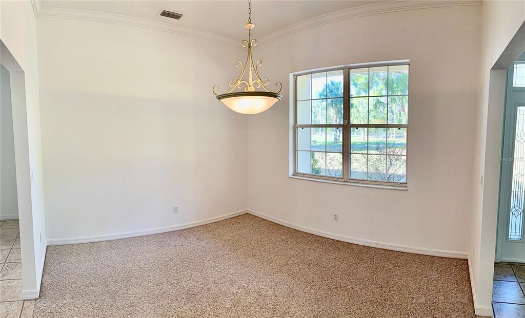 A carpeted home office features a ceiling fan, a large window, and a computer desk — 3701 W ANTHONY ROAD, OCALA, FL