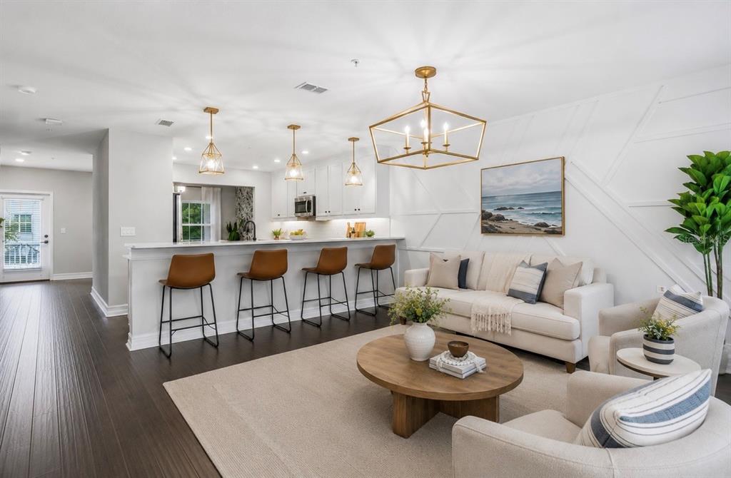 An open-concept living area features a kitchen with bar seating and a white sofa — 5120 BRIDGE STREET UNIT 5, TAMPA, FL