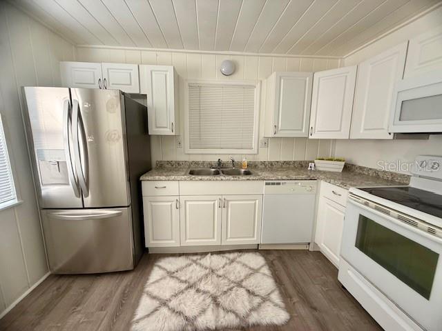 A kitchen features white cabinets, stainless steel appliances, a double sink, and wood-look flooring — 31538 ANDERSON DRIVE, TAVARES, FL