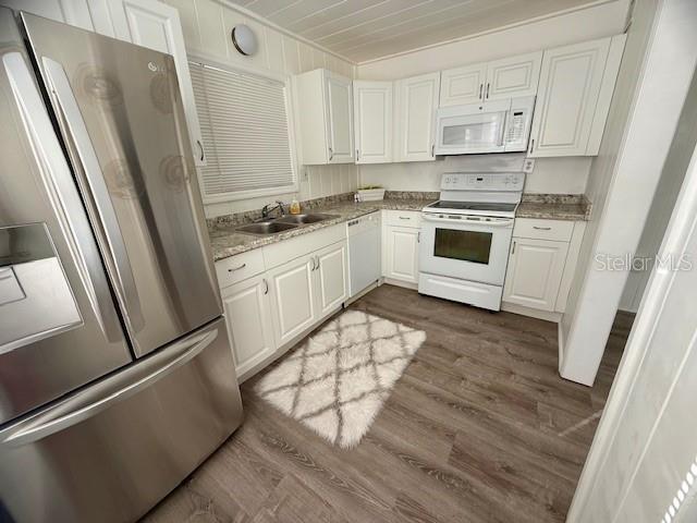 A kitchen features white cabinets, stainless steel appliances, and wood-look flooring — 31538 ANDERSON DRIVE, TAVARES, FL