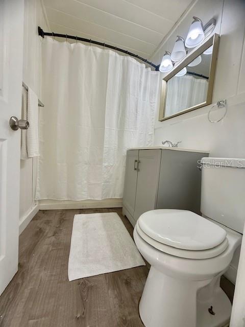 A bathroom features a white shower curtain, a gray vanity, a mirror, and a toilet — 31538 ANDERSON DRIVE, TAVARES, FL