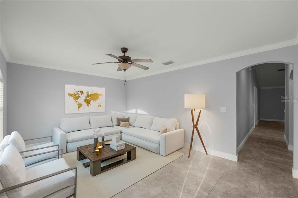 A living room features a white sectional sofa, two armchairs, a wooden coffee table, and tile flooring — 16376 SE 81ST COURT, SUMMERFIELD, FL