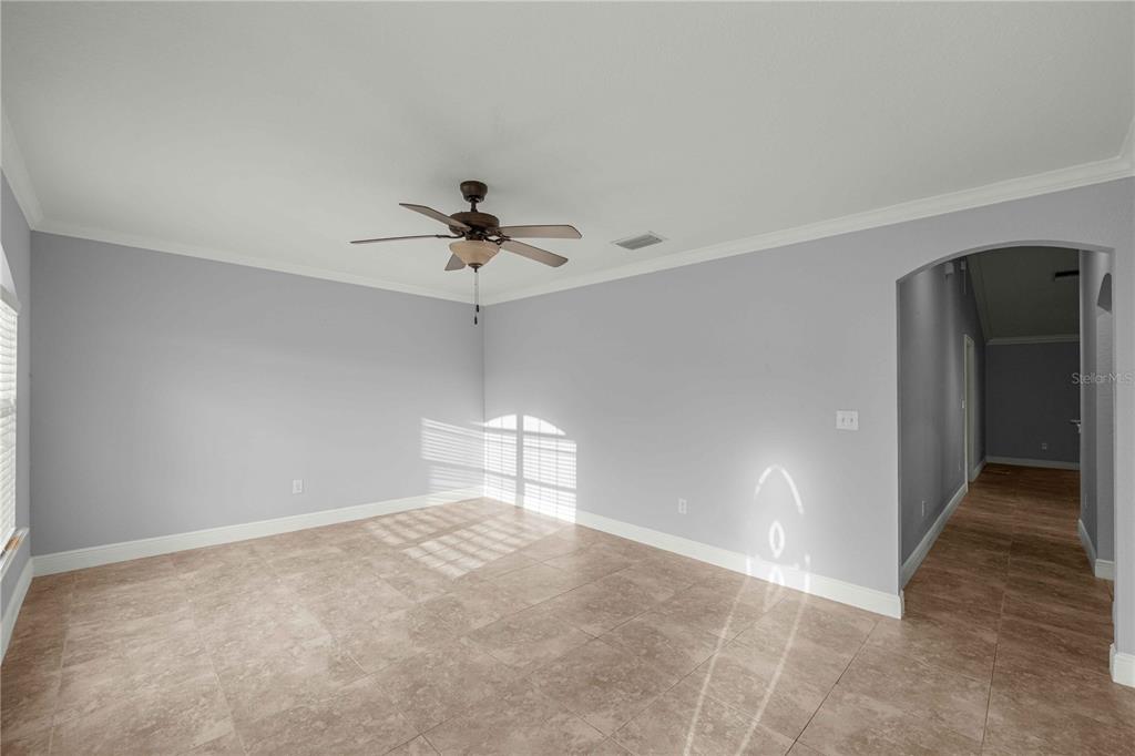 An empty room with light gray walls, tile flooring, and a ceiling fan — 16376 SE 81ST COURT, SUMMERFIELD, FL