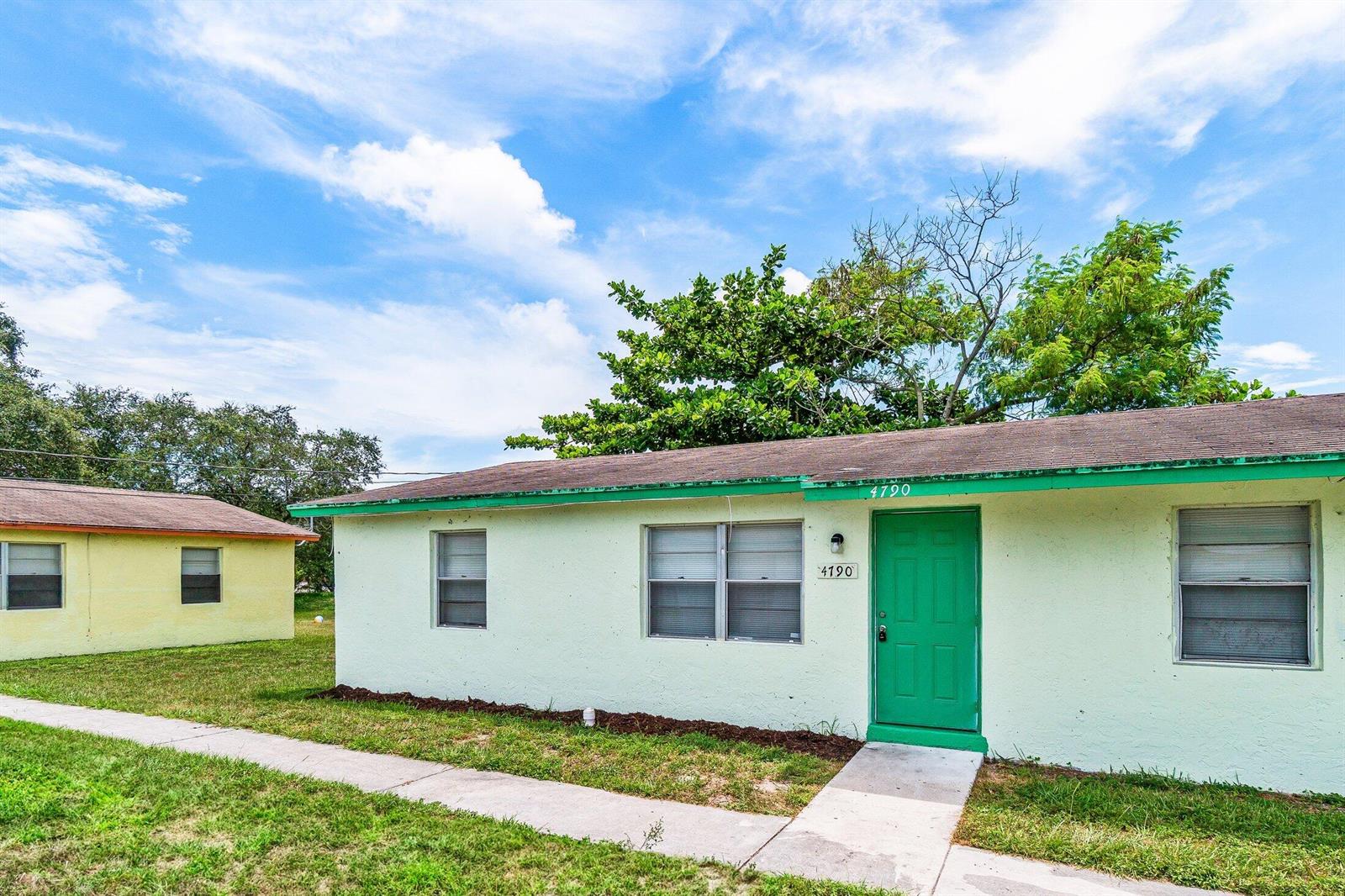 A light green single-story house with a green door and a sidewalk in front — 4790 Gulfstream Road, FL 33461, FL