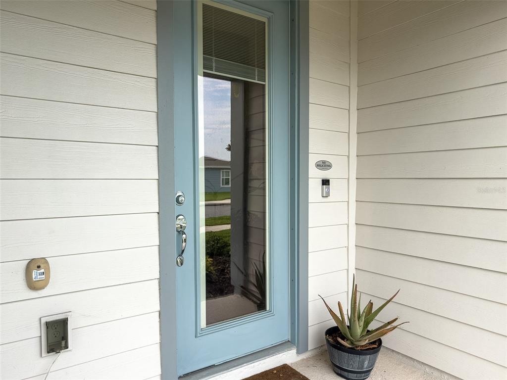 A light blue front door with a glass panel sits on a white-sided porch — 5640 PINELAND RUN, ORLANDO, FL