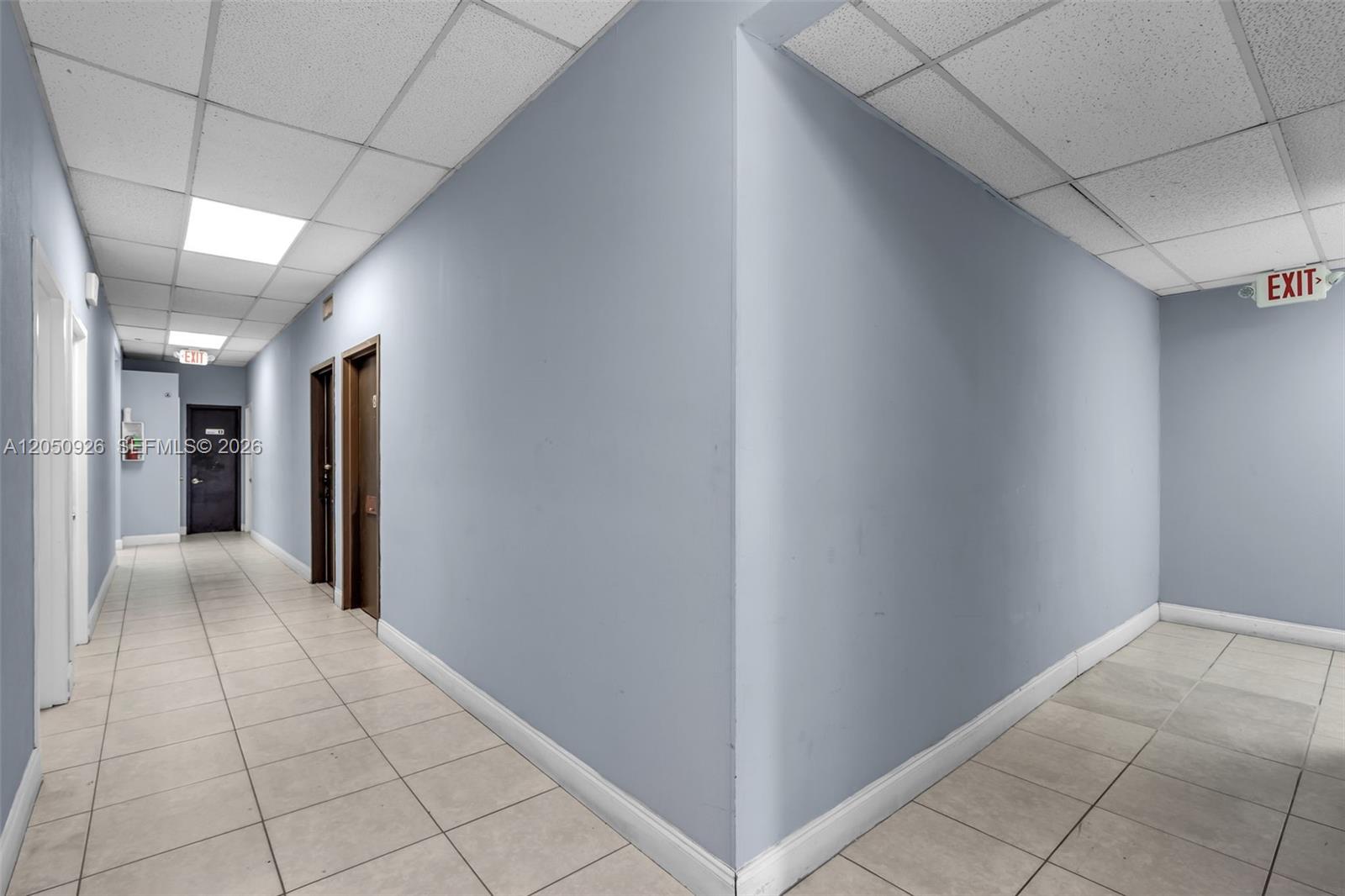A hallway with light blue walls, tiled floors, and a drop ceiling with recessed lighting — 1879 NW 7th St # 2, Miami FL 33125, MIAMI, FL