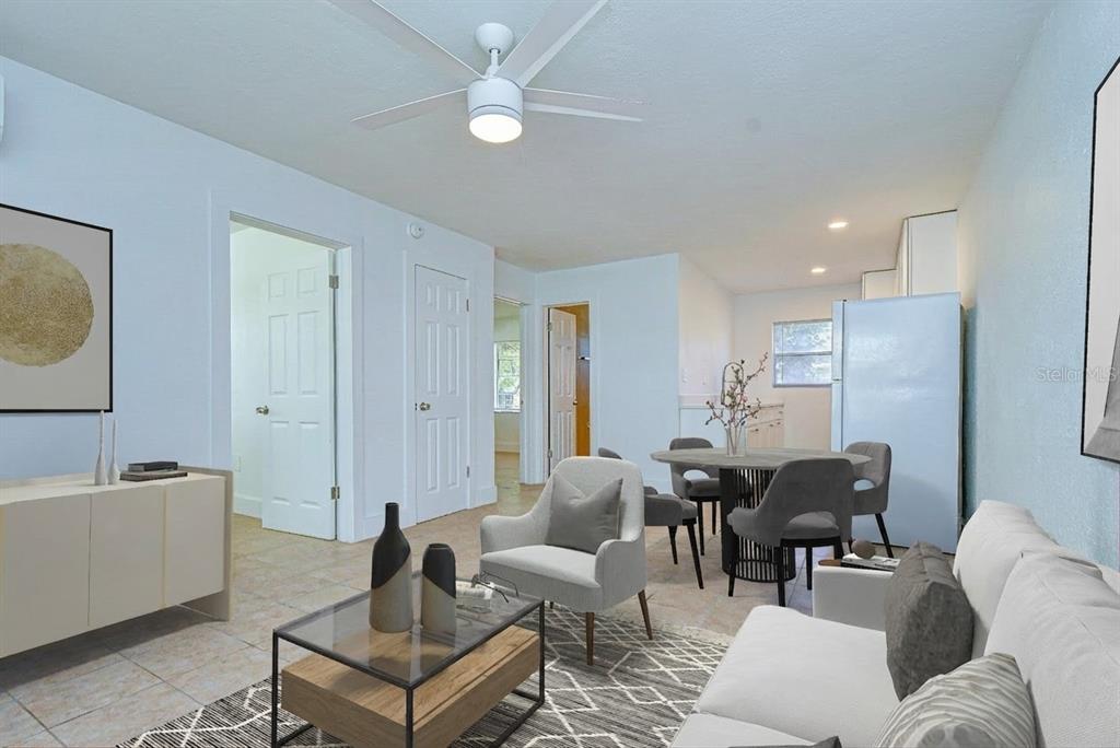 This is a digitally staged living and dining area with tile flooring and a ceiling fan — 3017 49TH STREET S UNIT 12, GULFPORT, FL