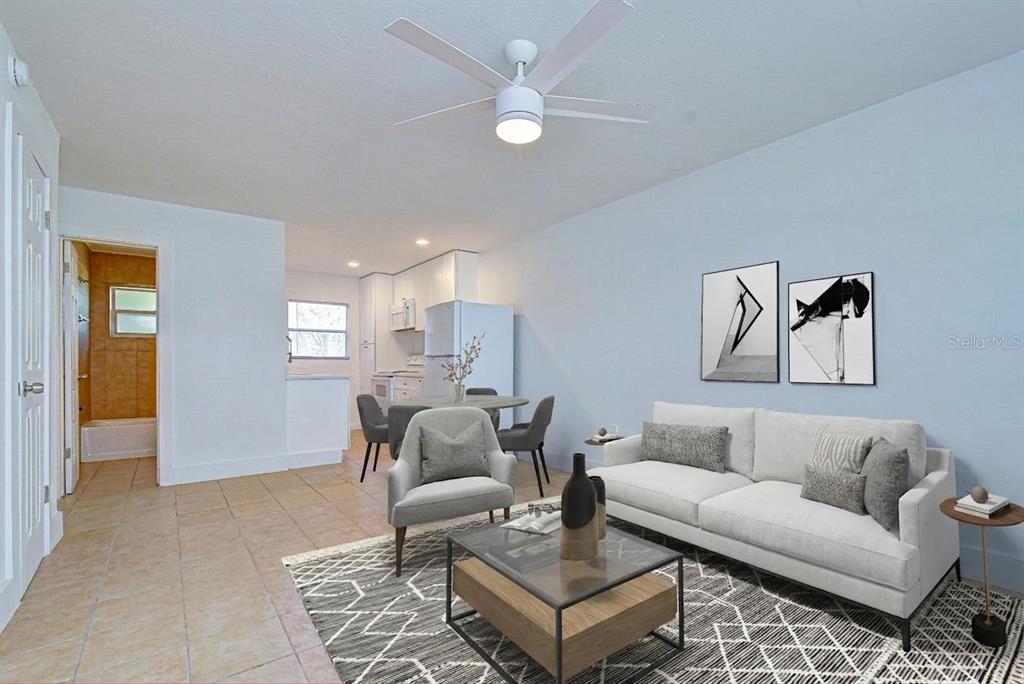 A living room with tile floors, a ceiling fan, and an adjacent kitchen area — 3017 49TH STREET S UNIT 12, GULFPORT, FL