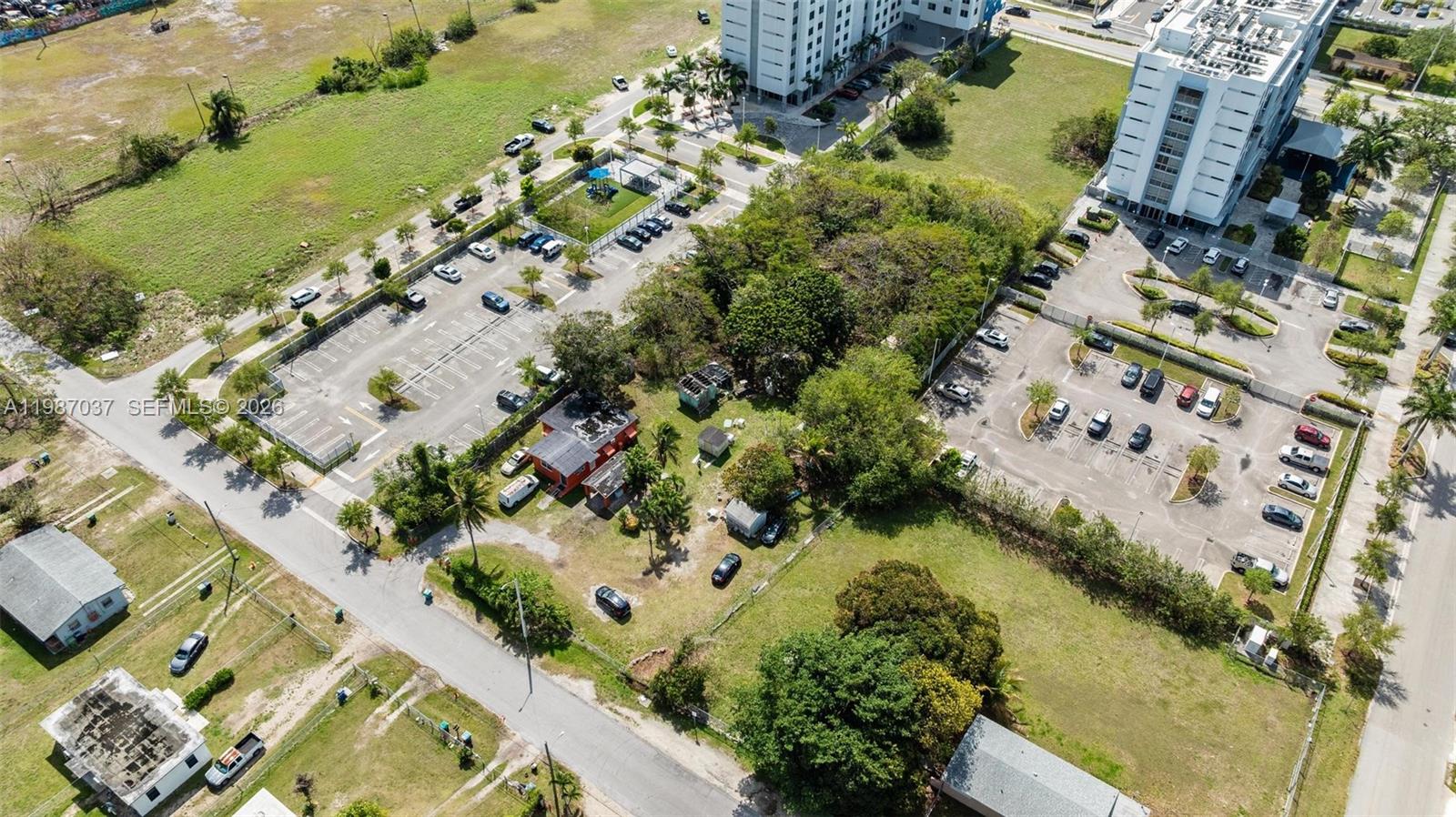 An aerial view shows a residential lot with a small house surrounded by parking lots — 11870 SW 214th St, Miami FL 33177, MIAMI, FL